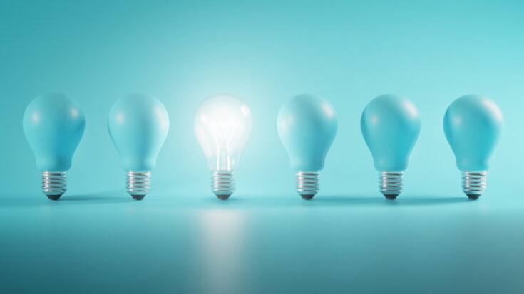 Outstanding Idea Concept. Glowing Bulb Between Unlit Blue Bulbs Minimal.