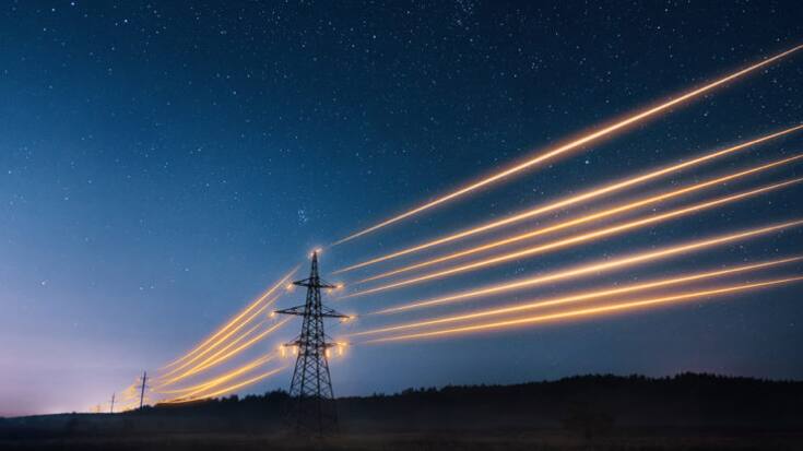 Electricity transmission towers with orange glowing wires the starry night sky. Energy infrastructure concept.
