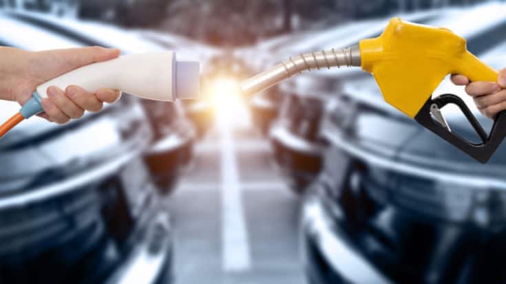 Human hands holding electric plug and gasoline nozzle