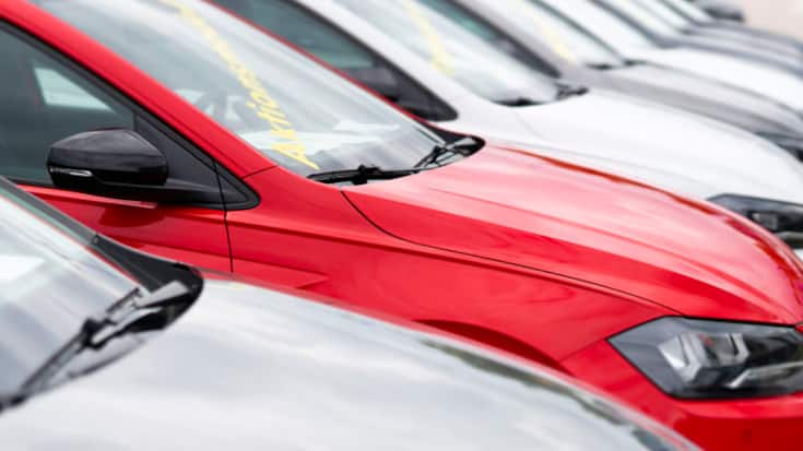 Hamburg, Germany - August 8, 2021: A number of used vehicles parked at a public car dealer. A red vehicle stands out in particular, in Hamburg, Germany