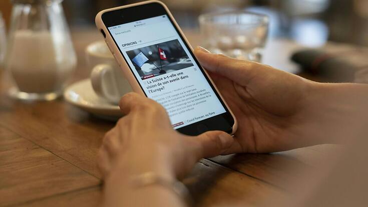 Une personne consulte le journal Le Temps sur son smartphone: de nombreux titres sont utilisés de manière croissante en ligne plutôt que sur papier.