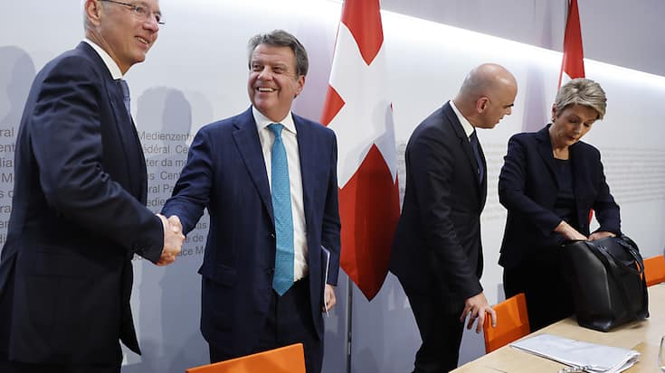 Les présidents de Credit Suisse Axel Lehmann (à gauche) et d'UBS Colm Kelleher se serrent la main à la fin de la conférence de presse d'annonce du rachat du CS par l'UBS, aux côtés des conseillers fédéraux Alain Berset et Karin Keller-Sutter.