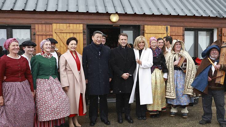 Emmanuel Macron et Xi Jinping, accompagnés de leurs épouses, prennent la pose avec des danseurs traditionnels.
