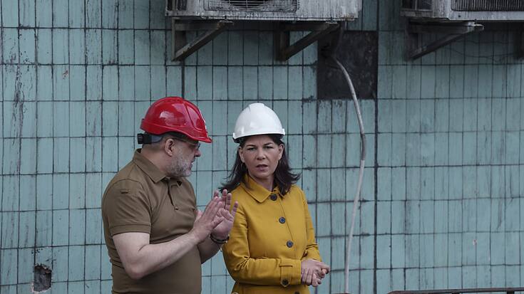 La cheffe de la diplomatie allemande visite une centrale thermique endommagée par les bombardements russes en compagnie du ministre ukrainien de l'énergie Herman Halushchenko.