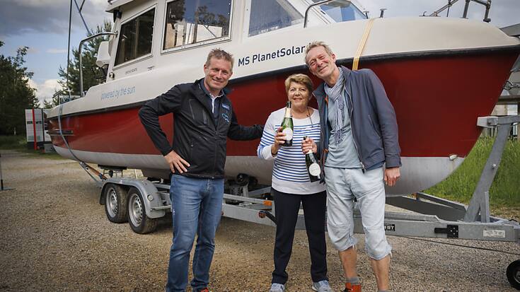L'explorateur suisse Raphael Domjan et Marc-Antoine Kaeser, directeur-conservateur du Latenium, avec au centre, Maryvonne Falco, veuve d'Albert Falco, second du Commandant Cousteau lors de leur expédition sur le lac Titicaca il y a 50 ans, après le baptême du bateau PlanetSolar.