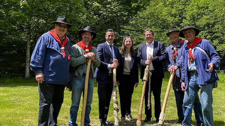 Le conseiller fédéral Albert Roesti pose avec le conseiller d'Etat vaudois Vassilis Venizelos et la conseillère municipale de la ville de Lausanne Natacha Litzistorf, entourés des Brigands du Jorat.