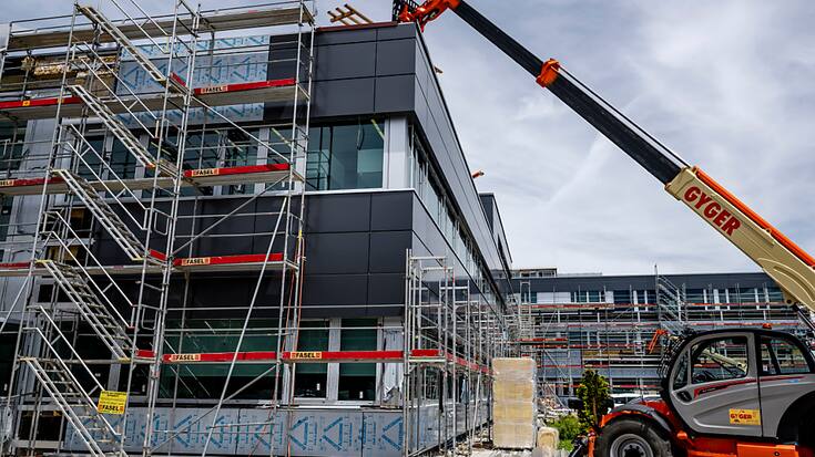 Des bâches recouvrent le chantier de l'entreprise Sellita Watch en reconstruction, une année après la tempête