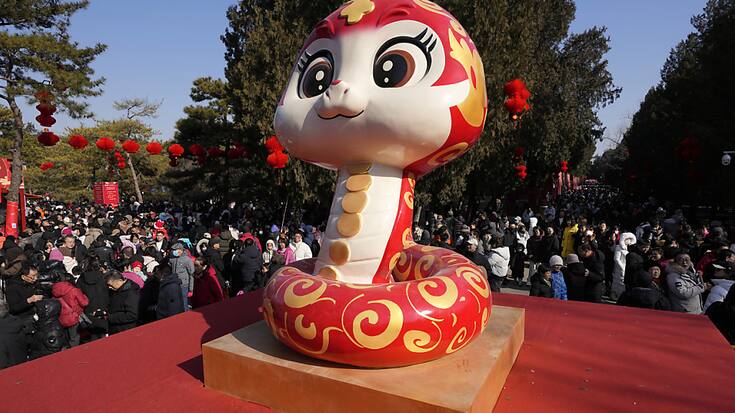 Un serpent, symbole de l'année qui commence, devant un temps à Pékin.