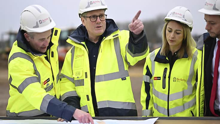 Le Premier ministre britannique Keir Starmer (au centre) s'est rendu jeudi matin sur un site de construction au nord de Londres afin de dévoiler les plans de son gouvernement pour "la prochaine génération de nouvelles villes".