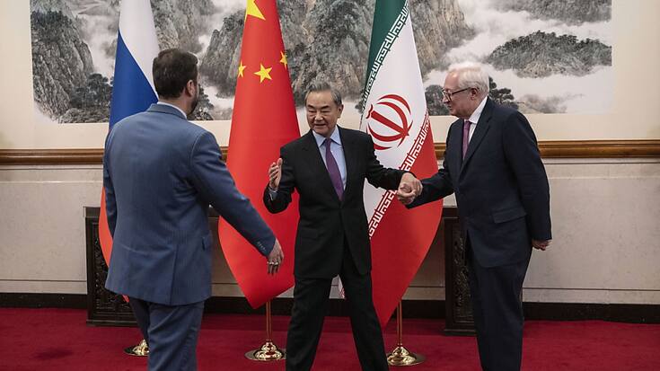 Le chef de la diplomatie chinoise Wang Yi (au centre) accueille les vice-ministres des affaires étrangères iranien et russe.