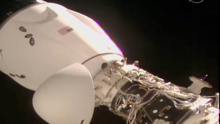 On voit la capsule de SpaceX, avec quatre personnes à bord, s'amarrer à la Station spatiale ISS,