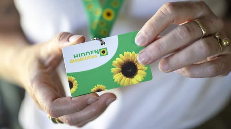 Après les CFF dans certaines gares, l'aéroport de Zurich introduit à son tour la possibilité pour les personnes souffrant d'un handicap non visible de porter un cordon vert à motifs de tournesols autour du cou.