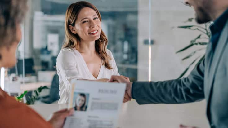 Un recruteur serrant la main d'une candidate après un entretien d'embauche.