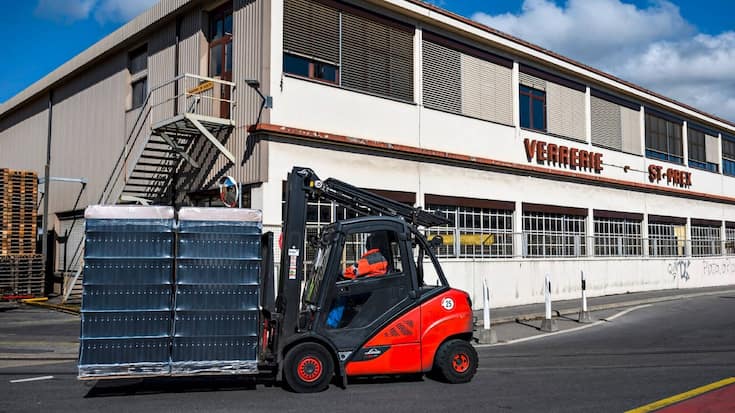 Un ouvrier transporte des bouteilles devant le site du groupe Vetropack