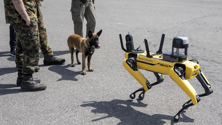 Un chien observe un robot de garde non armé, fabriqué par Boston Dynamics. En Suisse aussi, la robotique figure parmi les domaines de recherche prioritaires pour faire face aux menaces actuelles.