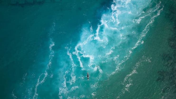 Top view  of a man paddles a kayak in raging sea water