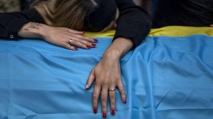 Des combats se déroulent actuellement pratiquement sur toute la ligne de front en Ukraine, selon la présidence. Une femme pleure mercredi son mari tué au combat.