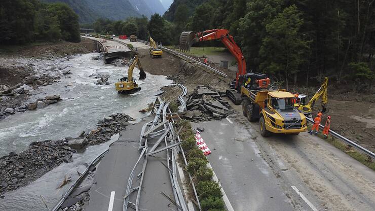 Les pelleteuses sont à pied d'oeuvre, aux limites de leurs capacités, le long de la chaussée détruite de l'A13, à Lostallo (GR).