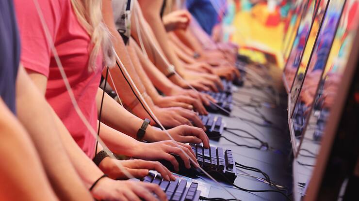 Des visiteurs du salon testent des jeux informatiques à la Gamescom, le salon du jeu vidéo et de l'informatique de Cologne.