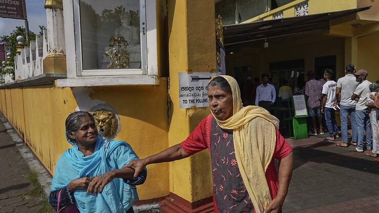 Des femmes quittent le bureau de vote après avoir glissé leur bulletin dans l'urne à Colombo.