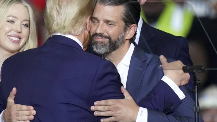 Donald Trump Jr, ici à droite, embrassant son père, a "seul droit de vote et autorité sur tous les titres détenus par le trust".