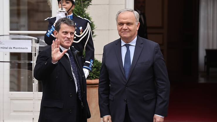Le ministre français de l'Outre-mer sortant, François-Noël Buffet (à droite), accueille le nouveau ministre de l'Outre-mer, Manuel Valls (à gauche), lors de la cérémonie de passation des pouvoirs au ministère français de la Justice à Paris mardi.