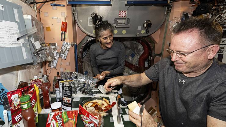 Les astronautes Suni Williams et Butch Wilmore, tous deux ingénieurs de vol de l'Expédition 71, préparent une pizza dans la cuisine de la Station spatiale internationale située à l'intérieur du module Unity en septembre dernier.