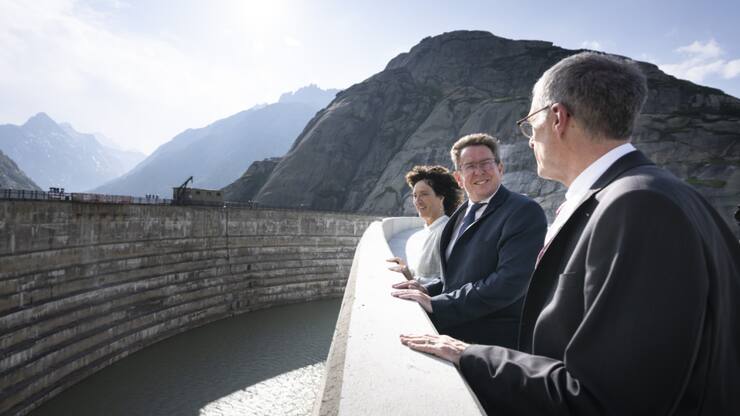 Barbara Egger-Jenzer présidente du conseil d'administration des KWO (gauche), le conseiller fédéral Albert Roesti (centre) et Daniel Fischlin CEO des KWO se tiennent sur le nouveau barrage de Spitallamm, haut de 113 mètres au lac du Grimsel vendredi.