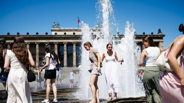 Des touristes se rafraîchissent dans une fontaine à Berlin.