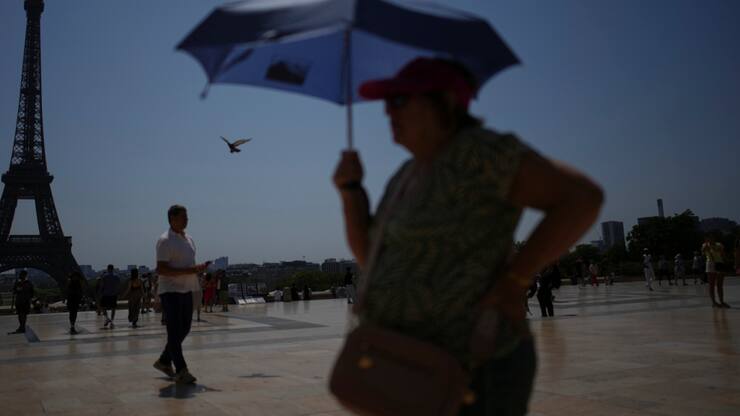 Un touriste s'abrite du soleil avec une ombrelle, sur le Trocadero à Paris, lors d'un épisode caniculaire de juillet. (image d'illustration)