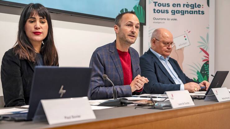 Laure de Courten, Cheffe de l'inspection cantonale de l'emploi et de l'aide sociale, Mathias Reynard, Conseiller d'Etat valaisan, Niklaus Furger, representant des Communes, de gauche a droite, parlent lors d'une conference de presse sur le dispositif eBadges, un nouveau systeme de contrele individuel des travailleurs sur les chantiers le vendredi 6 decembre 2024 a Sion. (KEYSTONE/Jean-Christophe Bott)