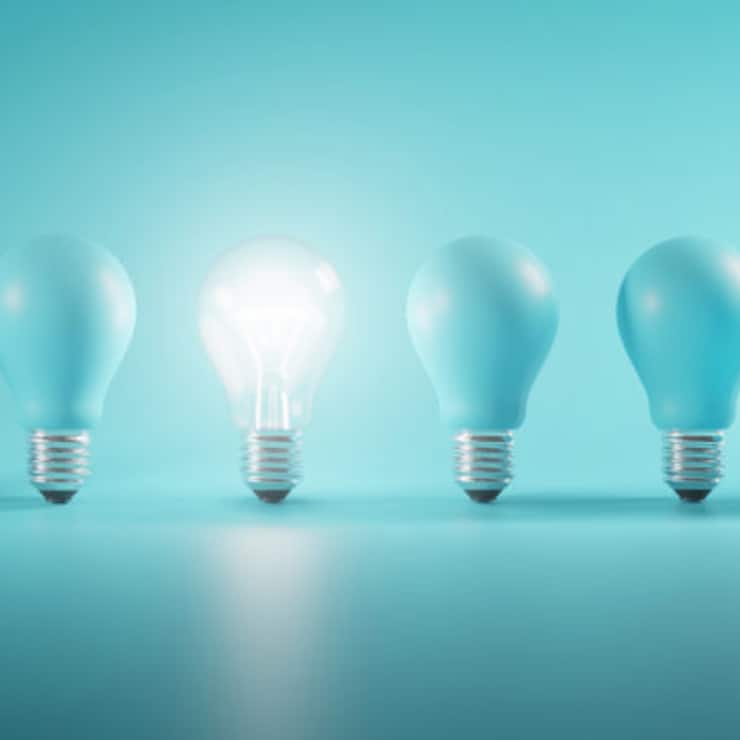 Outstanding Idea Concept. Glowing Bulb Between Unlit Blue Bulbs Minimal.