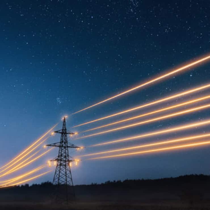 Electricity transmission towers with orange glowing wires the starry night sky. Energy infrastructure concept.