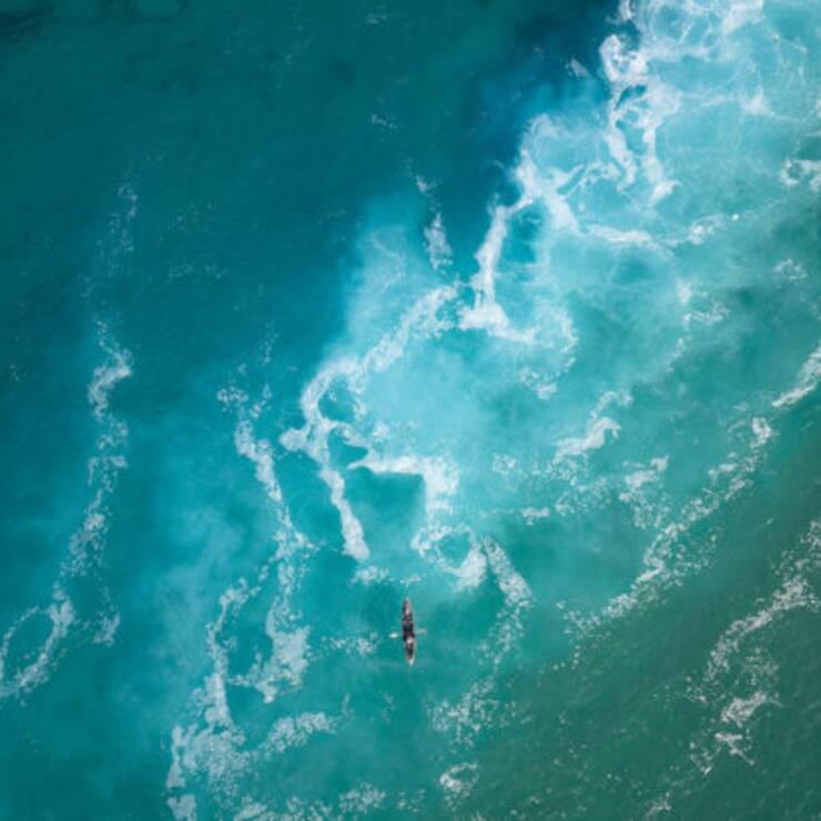 Top view  of a man paddles a kayak in raging sea water