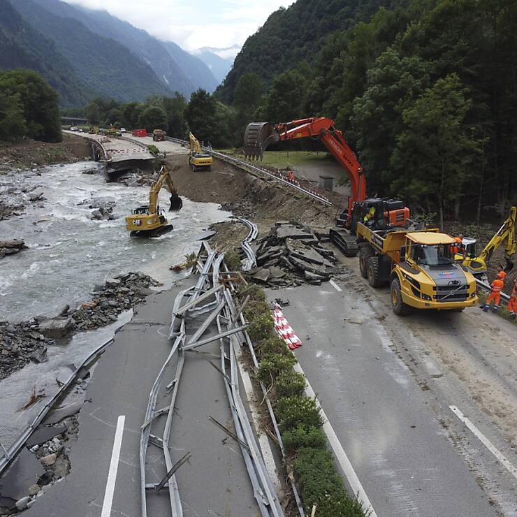 Les pelleteuses sont à pied d'oeuvre, aux limites de leurs capacités, le long de la chaussée détruite de l'A13, à Lostallo (GR).