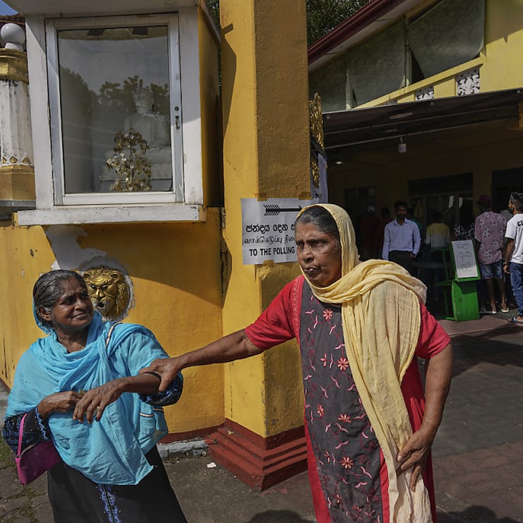 Des femmes quittent le bureau de vote après avoir glissé leur bulletin dans l'urne à Colombo.