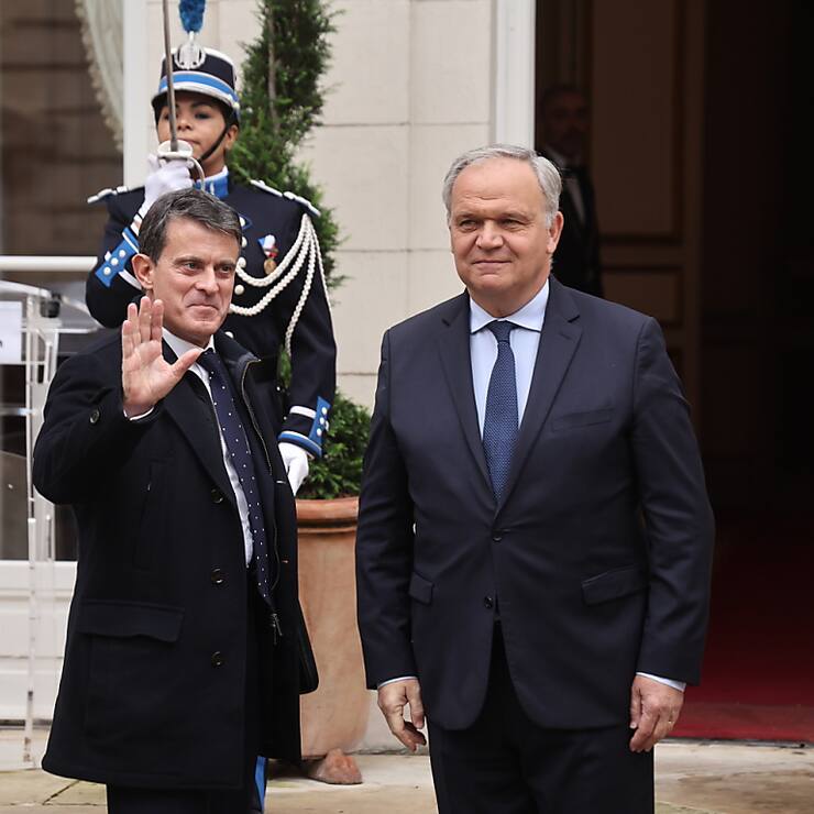 Le ministre français de l'Outre-mer sortant, François-Noël Buffet (à droite), accueille le nouveau ministre de l'Outre-mer, Manuel Valls (à gauche), lors de la cérémonie de passation des pouvoirs au ministère français de la Justice à Paris mardi.