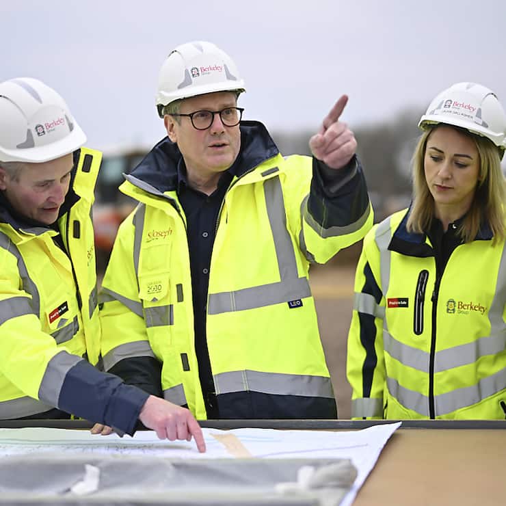 Le Premier ministre britannique Keir Starmer (au centre) s'est rendu jeudi matin sur un site de construction au nord de Londres afin de dévoiler les plans de son gouvernement pour "la prochaine génération de nouvelles villes".