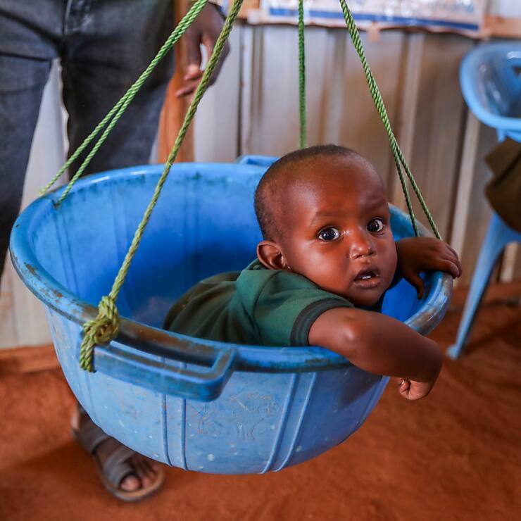 Dans un camp de déplacés en Somalie, un bébé est pesé lors d'un examen par un médecin et un nutritionniste pour prévenir la malnutrition dans une clinique de fortune (image symbolique).