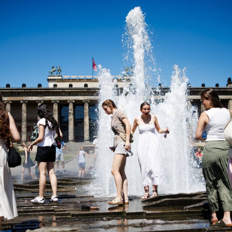 Des touristes se rafraîchissent dans une fontaine à Berlin.