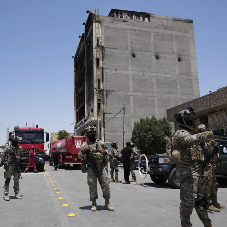Les forces de sécurité irakiennes rasemblées devant l'immeuble abritant le centre commercial où s'est déclaré l'incendie meurtrier.