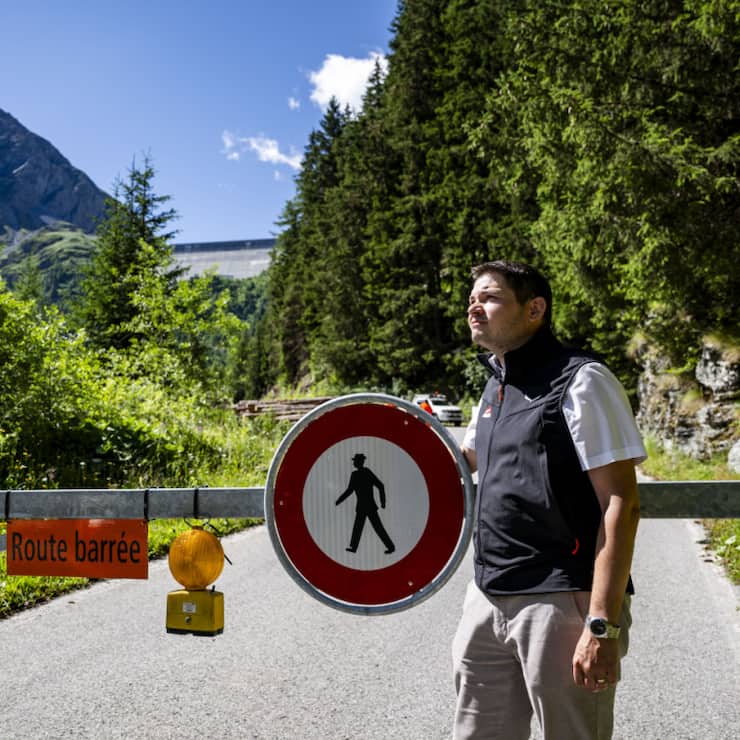 Gregory Logean, président de la commune d'Hérémence devant la barrière qui ferme la route, suite à l'éboulement de roches proche du barrage de la Grande Dixence jeudi 17 juillet.
