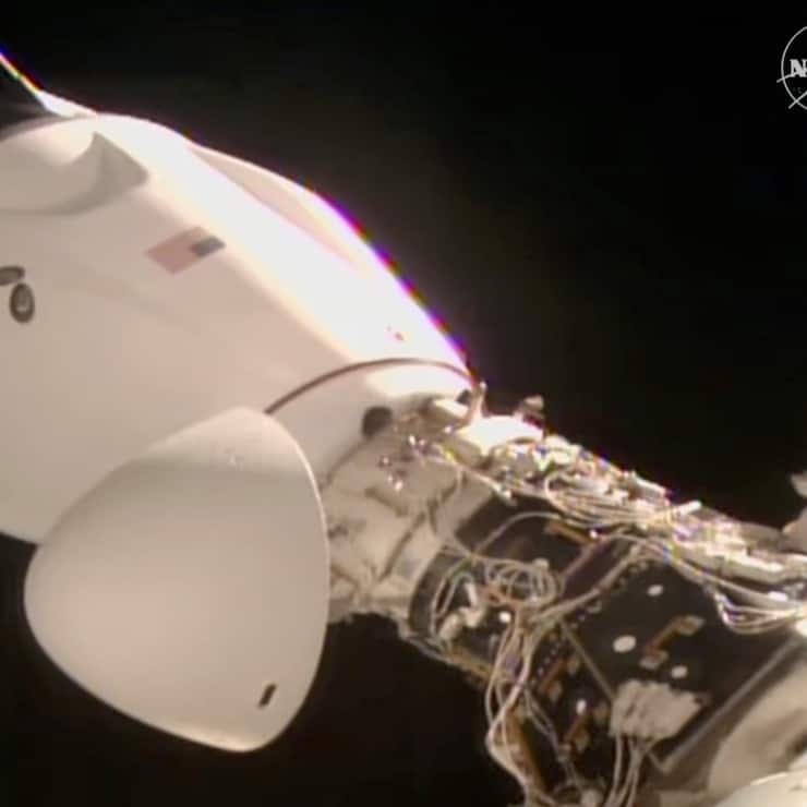 On voit la capsule de SpaceX, avec quatre personnes à bord, s'amarrer à la Station spatiale ISS,