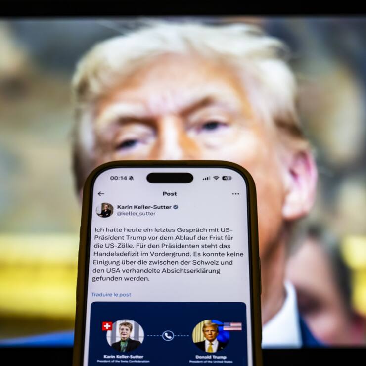 Le message de la présidente de la Confédération Karin Keller-Sutter sur X concernant les droits de douane, devant un portrait du président américain Donald Trump. (archive)