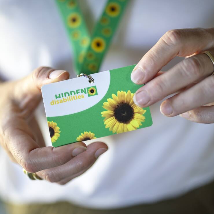 Après les CFF dans certaines gares, l'aéroport de Zurich introduit à son tour la possibilité pour les personnes souffrant d'un handicap non visible de porter un cordon vert à motifs de tournesols autour du cou.