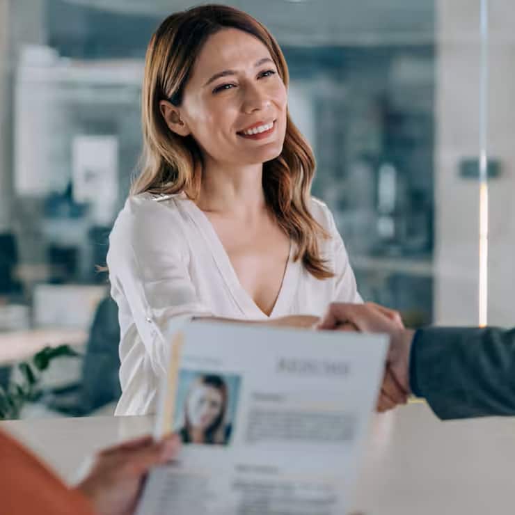 Un recruteur serrant la main d'une candidate après un entretien d'embauche.