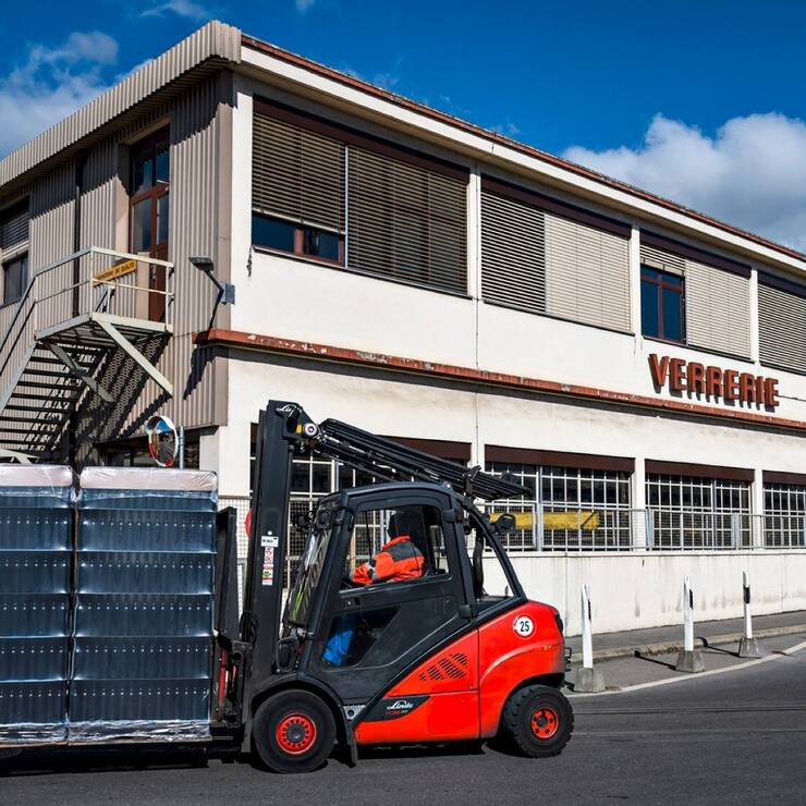 Un ouvrier transporte des bouteilles devant le site du groupe Vetropack
