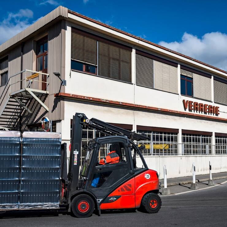 Un ouvrier transporte des bouteilles devant le site du groupe Vetropack