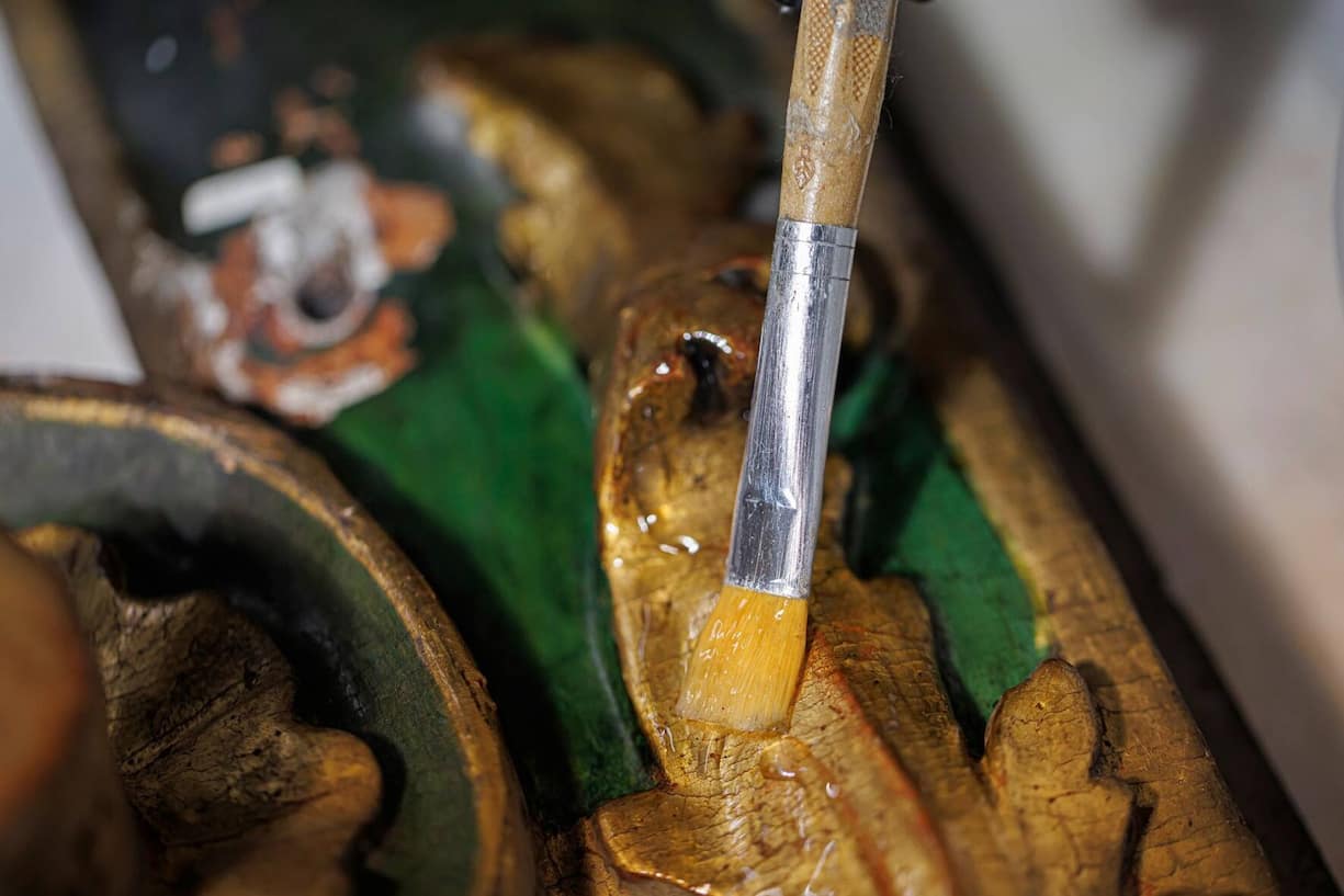 Les dorures d’un ornement latéral sont nettoyées  au solvant gel.