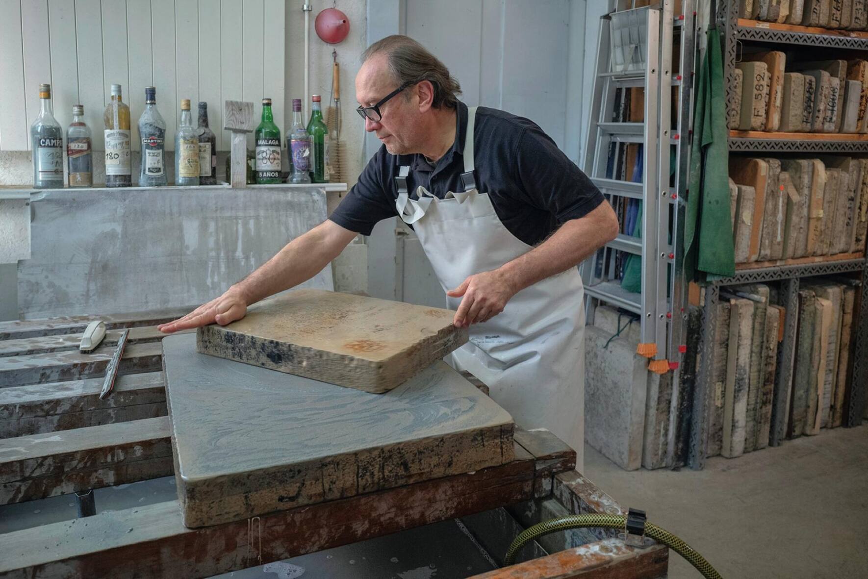 La lithographie commence par la préparation de la pierre, à la main, avec de l’eau et un peu de sable calibré qui donnera son grain au futur dessin.